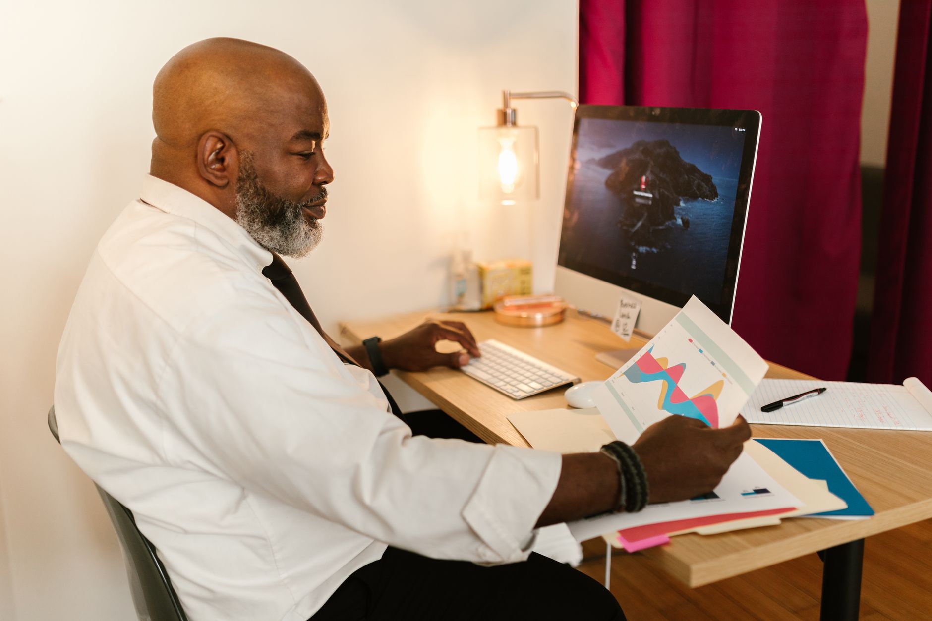 Older man working at office desk, representing over 50s returning to work UK